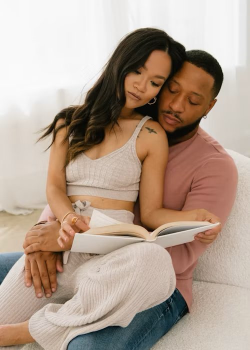 A couple reading a book together at home